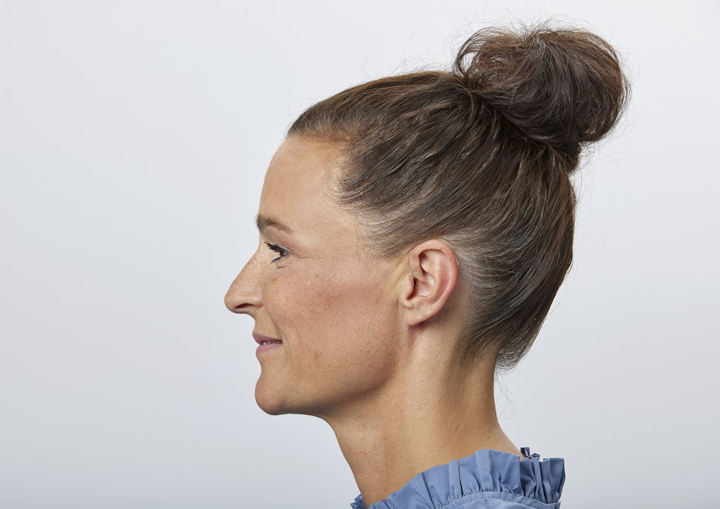 Oticon Reveal hearing aid worn behind the ear